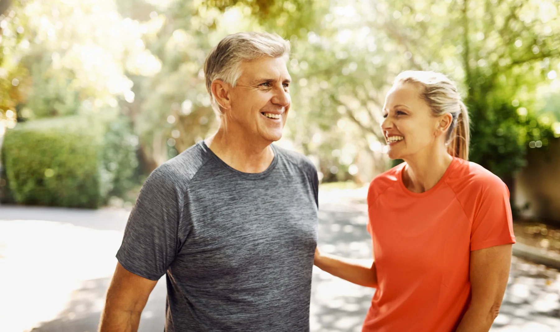 Couple in their 50s walking outdoors and smiling