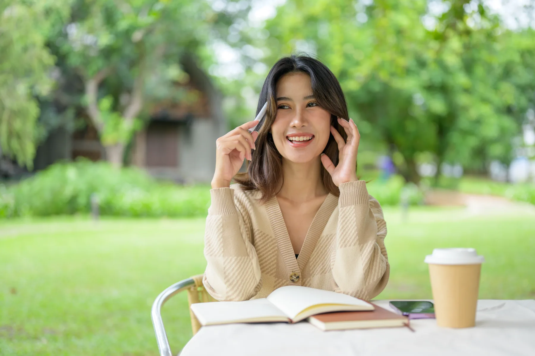 Young woman outdoors in a tan cardigan, natural light