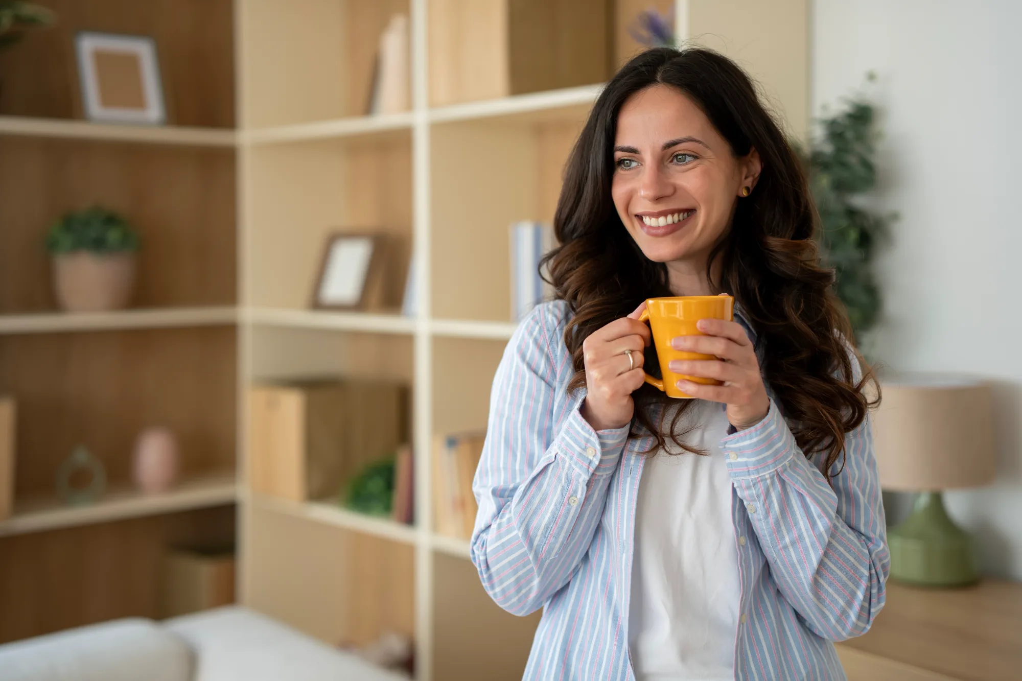 Woman relaxing at home with a mug, warm morning light